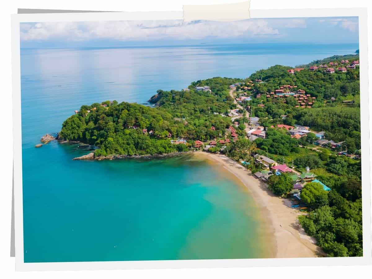 Kantiang Bay auf Ko Lanta in Thailand mit türkisblauem Wasser, Strand und grünen Hügeln aus der Luft
