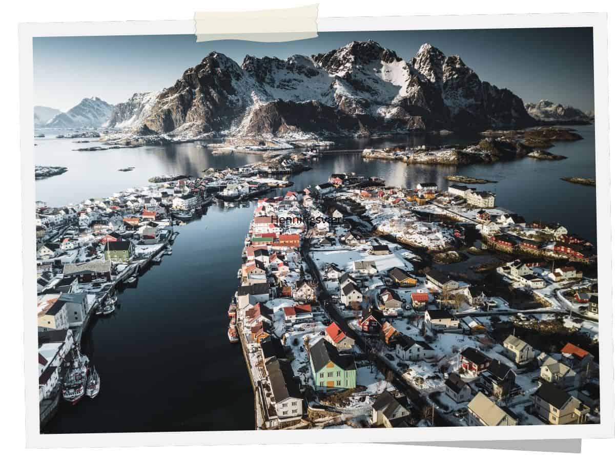 Luftaufnahme von Henningsvær auf den Lofoten mit Hafen, Inseln und Bergkulisse