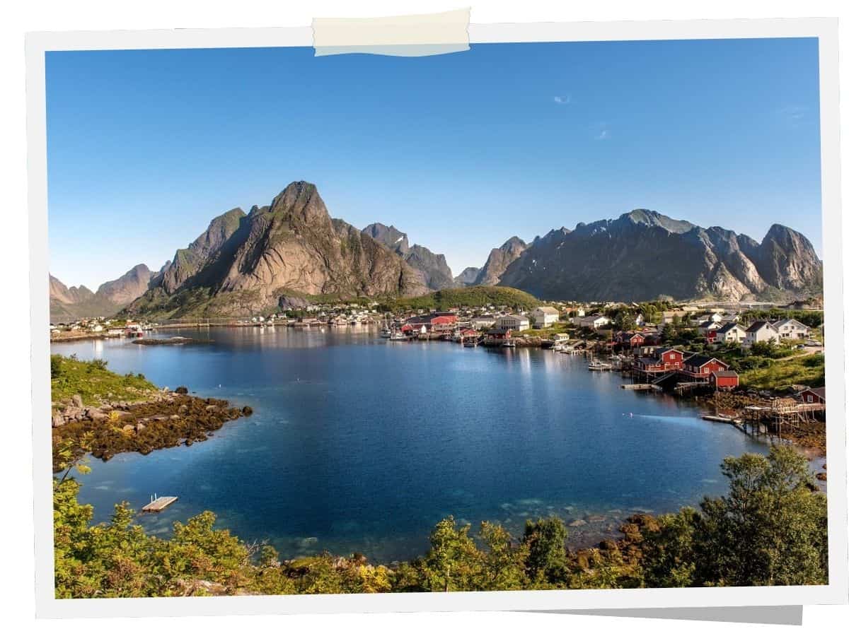 Fischerdorf Reine auf den Lofoten mit Fjord und markanter Bergkulisse in Norwegen