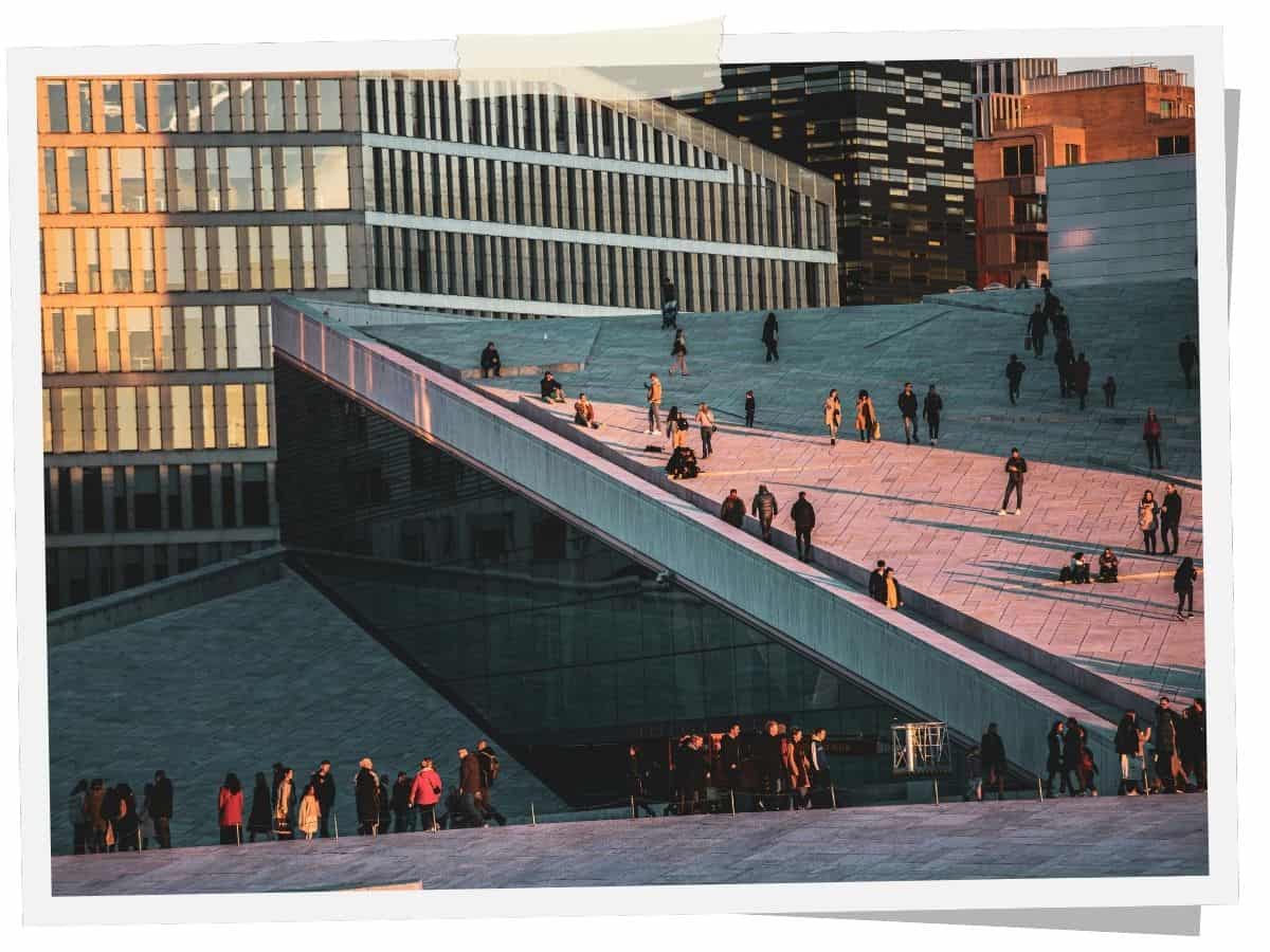 Besucher auf dem begehbaren Dach des Opernhauses in Oslo mit moderner Architektur am Oslofjord