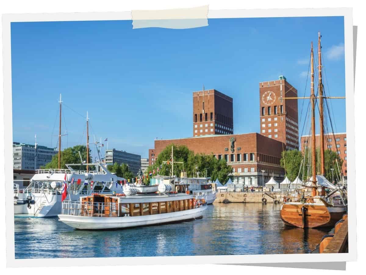 Osloer Rathaus am Hafen mit historischen Segelschiffen und Booten am Oslofjord